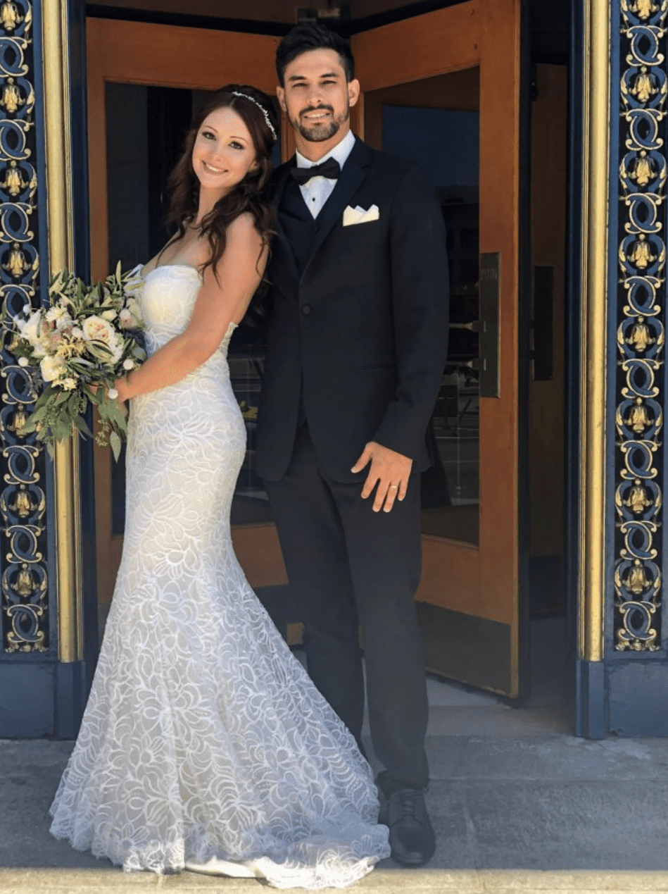 Сouple wearing a light gray gown and a black suit